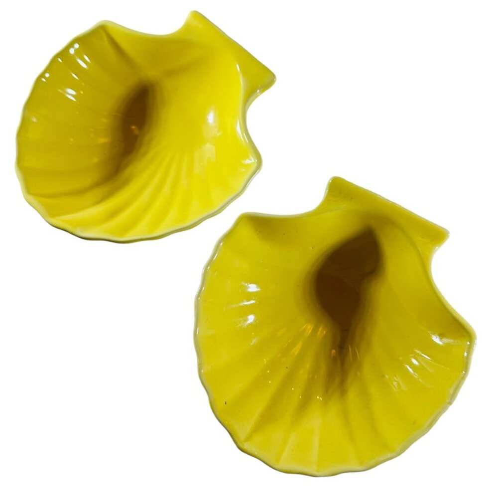Two Little bright yellow clam shell dishes, sushi, sauces, kitty food.